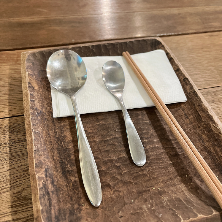 カフェ店内　食事前、気のトレイの上にカトラリーが行儀よく並べられる　