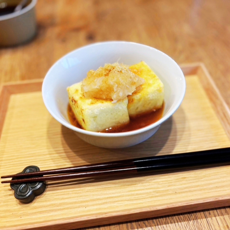 白い小鉢に盛った、大根おろしをのせた揚げ出し豆腐